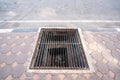 Stained steel grill sewer cover or sewage drain cover, on public footpath, copy space on the road Royalty Free Stock Photo