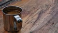 Stainless coffee cup on wooden table in outdoor. Copy space on the right.