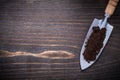 Stainless hand spade with soil on vintage wooden