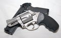 A stainless 357 magnum revolver on top of a black 40 caliber semiautomatic pistol