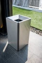 Stainless modern silver square shape trash bin on dark floor Royalty Free Stock Photo