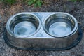 Stainless Steel Bowls With Fresh Water For Thirsty Dogs Put Outdoors On The Sidewalk Where People Walk With Their Pets On Hot