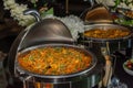 A stainless steel chafing dish filled with mixed vegetable curry at a catered event Royalty Free Stock Photo