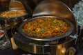 A stainless steel chafing dish filled with mixed vegetable curry at a catered event Royalty Free Stock Photo