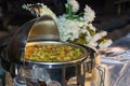 A stainless steel chafing dish with food on a catered buffet table Royalty Free Stock Photo