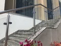 Stainless steel chrome plated finished hand rails with glass panels for an ramp or staircase steps for an building interiors for Royalty Free Stock Photo