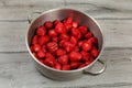 Stainless steel cooking pot full of strawberries on wooden desk. Royalty Free Stock Photo