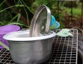 Stainless steel cooking pots are placed in the sink on the patio. Royalty Free Stock Photo