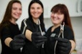 Stainless steel dental pliers, forceps for extracting teeth in gloved hands of blurred team of female dentists doctors