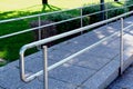 Stainless steel double rail along concrete tile paved handicapped ramp Royalty Free Stock Photo