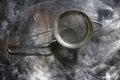 Stainless Steel Fine Mesh Strainer Colander Flour Sieve with Handle on dark background powdered with flour. Kitchenware Royalty Free Stock Photo