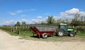 Stainless steel grape harvest trailer trailed by tractor in front of a rows of vineyard Royalty Free Stock Photo