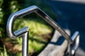 Stainless steel hand rail with grass in the background