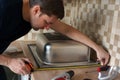 Stainless steel kitchen sink installation by man. Renovation of the kitchen.