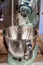 Stainless steel light green electric mixer. Hand or stand mixer. Kitchen device. Selective focus close-up