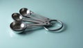 Stainless Steel Measuring Spoons on Light Blue Surface Royalty Free Stock Photo