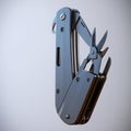 Stainless steel multi tool with open blades and scissors on a light gray background Royalty Free Stock Photo