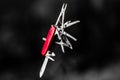 Stainless steel pocketknife with silver finish on blade and red handle in blurry background