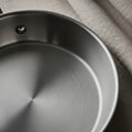 Stainless steel pot with a brushed finish, featuring a riveted handle. The interior has a concentric Royalty Free Stock Photo