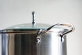 A stainless steel pot, a handy, durable, easy to clean kitchen tool, is shiny and sleek on the white background