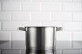 Stainless steel pot on the induction stove with white metro tile