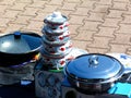 Stainless steel pots and pans with shiny surface placed on concrete pavement in a village market for sale Royalty Free Stock Photo