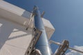 Stainless steel railing stairs from the outside of the building on a background of blue sky and beautiful clouds. Pipes, hinges, Royalty Free Stock Photo