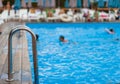 the stainless steel railing of the stairs by the pool with water Royalty Free Stock Photo