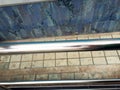 Stainless steel shiny handrail near the track, close-up view. Royalty Free Stock Photo