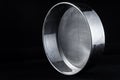 Stainless steel sieve for sifting cereal grain on a black background