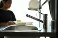 A stainless steel sink with a girl blur background in kitchen. Royalty Free Stock Photo