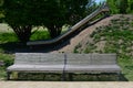 Stainless steel slide on a playground with grassy hills. playground with stone walkways made of natural sandstone stone. a pipelin