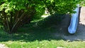 Stainless steel slide on a playground with grassy hills. playground with stone walkways made of natural sandstone stone. a pipelin