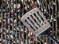 stainless steel spatula on empty barbecue grill grate over glowing charcoal, top view Royalty Free Stock Photo