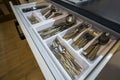 Stainless steel spoons, forks and knifes in cutlery box drawer in white kitchen cupboard Royalty Free Stock Photo