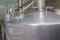 A stainless steel vat in the food industry at a brewery in the process of brewing beer. Background