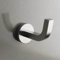 Stainless steel wall hook mounted on a smooth, light-colored surface. The hook Royalty Free Stock Photo