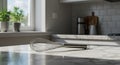 Stainless steel whisk resting on a marble countertop in a bright kitchen Royalty Free Stock Photo