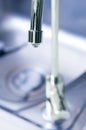 Stainless tap with water drop in modern kitchen. Royalty Free Stock Photo