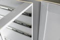 Stainless telescopic bayonet drawer slide guides, installed on a kitchen cabinet from gray chipboard. Accessories for Royalty Free Stock Photo