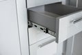 Stainless telescopic bayonet drawer slide guides, installed on a kitchen cabinet from gray chipboard. Accessories for Royalty Free Stock Photo