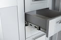 Stainless telescopic bayonet drawer slide guides, installed on a kitchen cabinet from gray chipboard. Accessories for Royalty Free Stock Photo