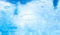 Stains circles on water from rain. Raindrops on pool blue water surface. blue water texture as background