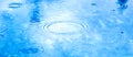 Stains circles on water from rain. Raindrops on pool blue water surface. blue water texture as background. Long web baner