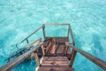 Stair down to crystal clear ocean from water villa private balcony Royalty Free Stock Photo