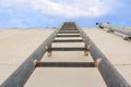 Stair old vertical industrial metal rusted to Water tank no safety rails on blue sky background