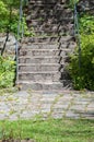 Stair structure of concrete with slate stones and iron railing. Stone walkway with grass and moss patterns Royalty Free Stock Photo