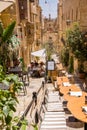 Staircase with building and umbrellas with cafe tables at restaurants in Valletta, Malta Royalty Free Stock Photo