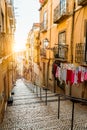 Staircase in the cobblestone street in Lisbon. Hanging laundry in typical narrow street. Sunset in the old downtown of
