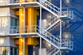 A staircase in a factory. Industrial photography for the background. Manufacturing and manufactory. Bright pipes against a blue wa